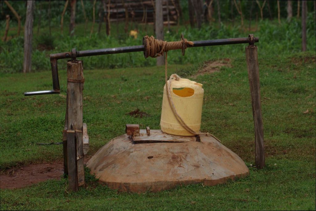 puits/cuve enterrée avec treuil à corde et couvercle en béton (remplace une photo de piscine hors-sujet)